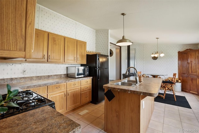 463 Snowshoe Ln, Lake George, CO 80827 - kitchen featuring black appliances, wallpapered walls, a sink, light tile patterned floors, and a center island with sink