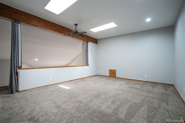 spare room with ceiling fan, carpet flooring, and beamed ceiling