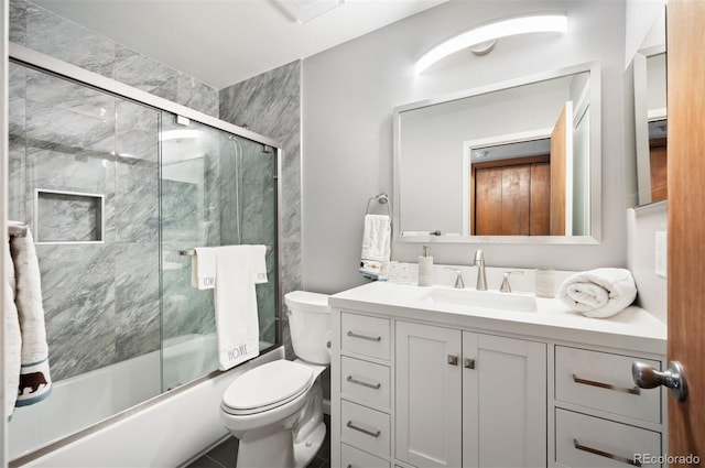 full bathroom featuring tile patterned flooring, toilet, bath / shower combo with glass door, and vanity