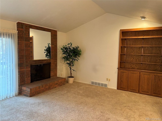 unfurnished living room with light carpet, a fireplace, and lofted ceiling