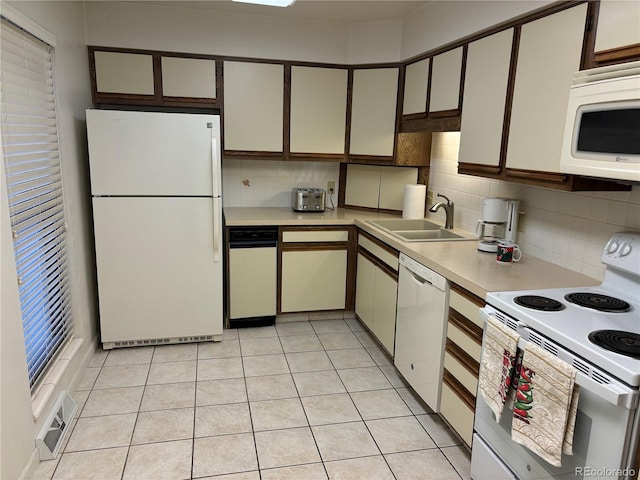 kitchen featuring white appliances, light countertops, visible vents, and a sink