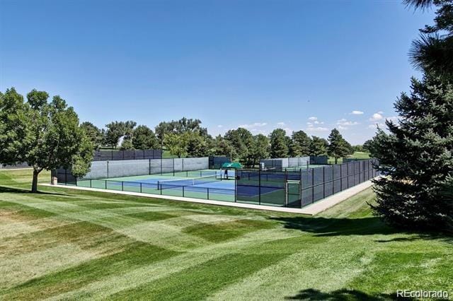 view of sport court with a yard and fence