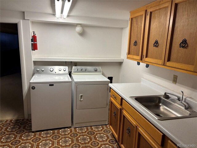 clothes washing area featuring cabinet space, independent washer and dryer, tile patterned floors, and a sink