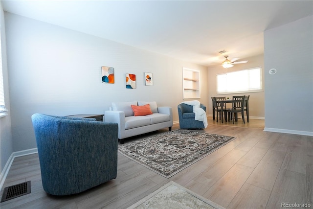 living room with wood-type flooring and ceiling fan