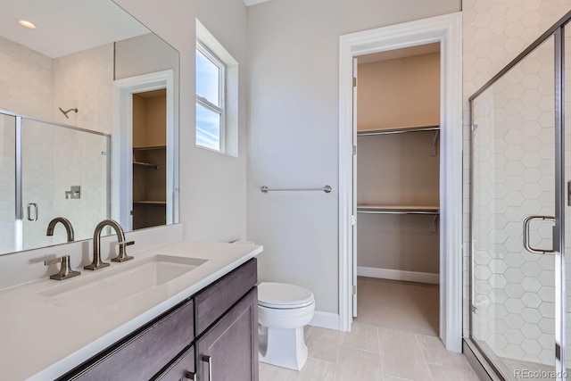 bathroom featuring vanity, tile patterned flooring, toilet, and an enclosed shower