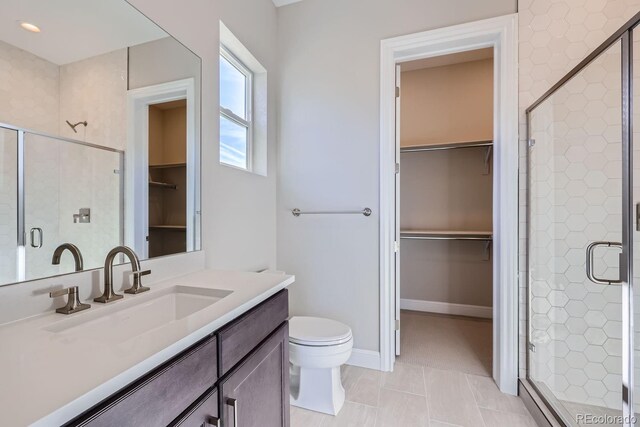full bathroom featuring a stall shower, toilet, and vanity