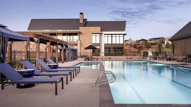 community pool featuring fence and a patio