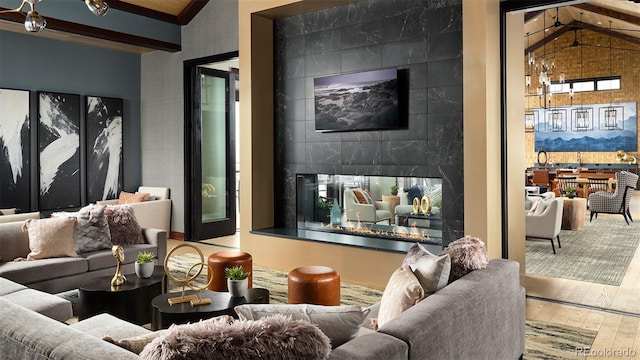 living room featuring hardwood / wood-style flooring, a tile fireplace, and lofted ceiling with beams