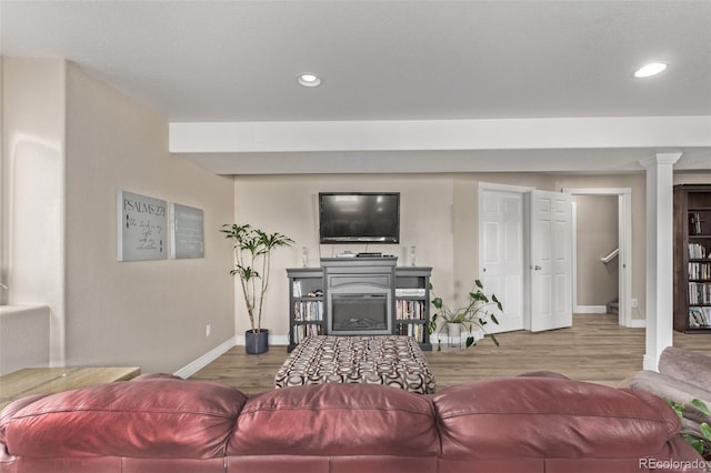 living area with a fireplace, baseboards, wood finished floors, and recessed lighting