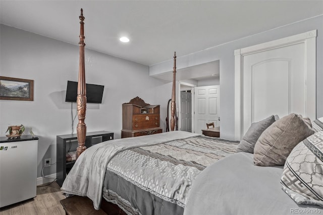 bedroom featuring freestanding refrigerator, baseboards, recessed lighting, and wood finished floors