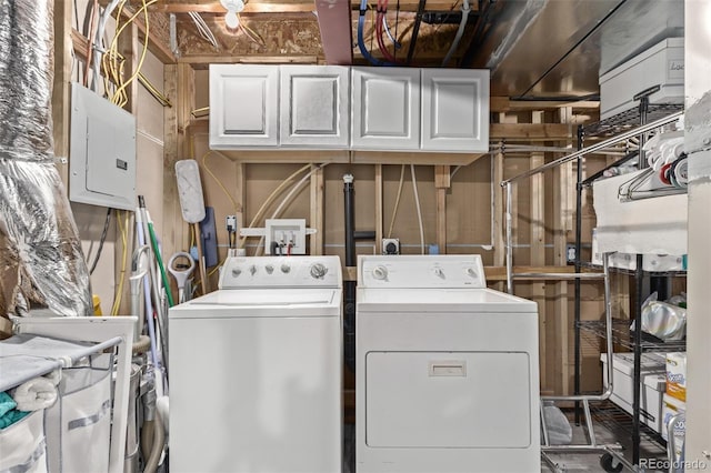 laundry area with washing machine and clothes dryer, cabinet space, and electric panel