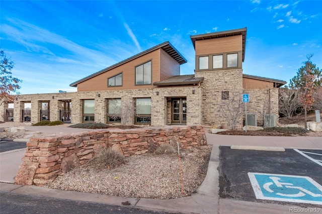 exterior space with uncovered parking and stone siding