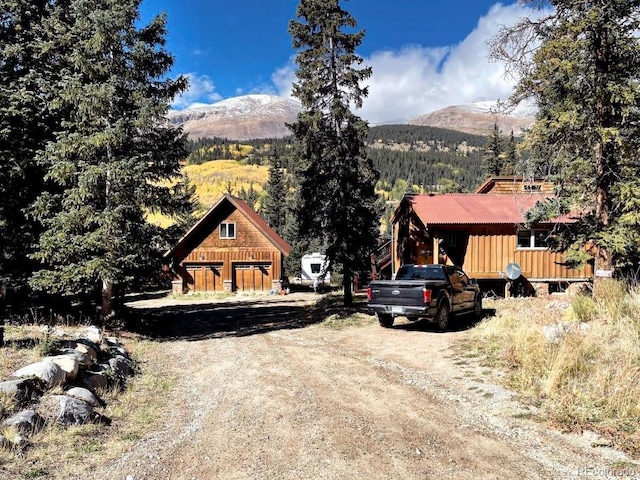 201 Nuthatch Dr, Alma, CO 80420 - view of front of home featuring a mountain view, a garage, a view of trees, and driveway