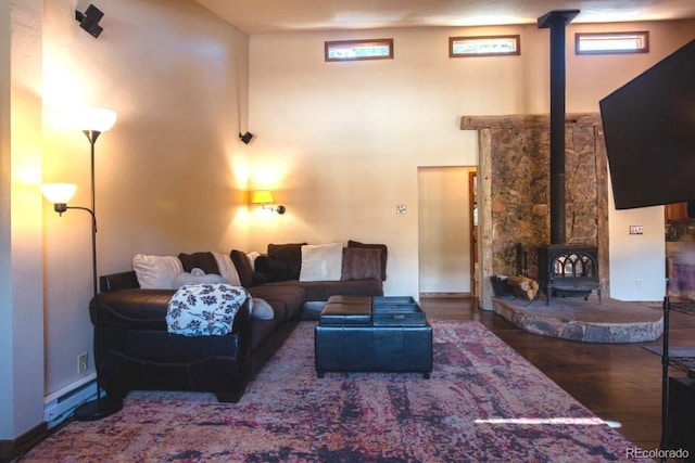 201 Nuthatch Dr, Alma, CO 80420 - living area featuring a wood stove, wood finished floors, baseboard heating, and a towering ceiling