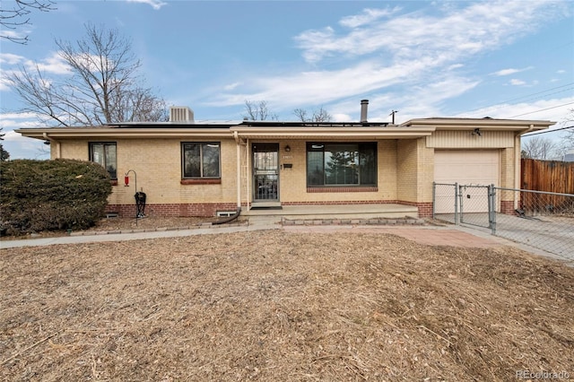 single story home featuring a garage, covered porch, and solar panels