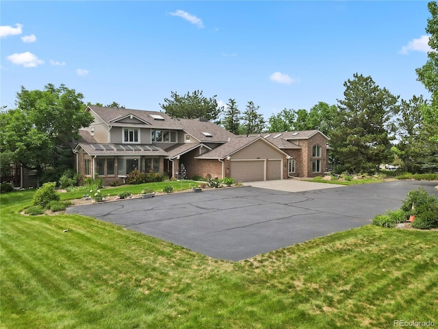 6895 S Norfolk St, Foxfield, CO 80016 - traditional-style house featuring a garage, driveway, a front yard, and brick siding
