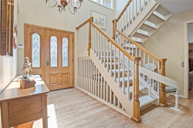 6895 S Norfolk St, Foxfield, CO 80016 - entrance foyer with wood finished floors, stairs, a chandelier, and a high ceiling