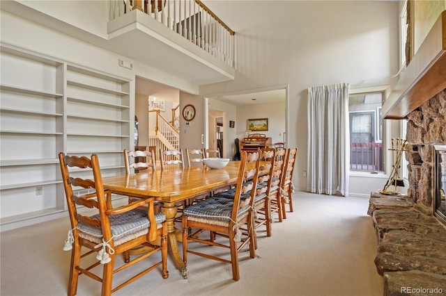 6895 S Norfolk St, Foxfield, CO 80016 - carpeted dining area featuring a high ceiling, a fireplace, built in features, and stairs