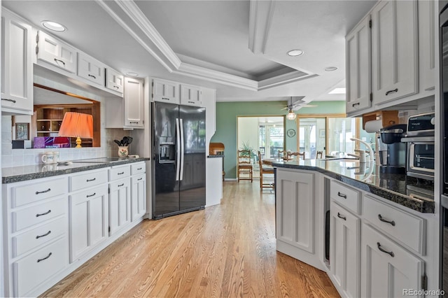 6895 S Norfolk St, Foxfield, CO 80016 - kitchen featuring black refrigerator with ice dispenser, a raised ceiling, ceiling fan, light wood finished floors, and backsplash