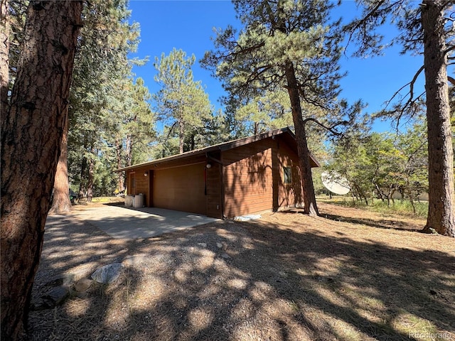 view of side of home featuring a garage and an outbuilding