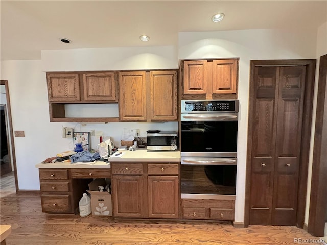 kitchen with appliances with stainless steel finishes and hardwood / wood-style floors