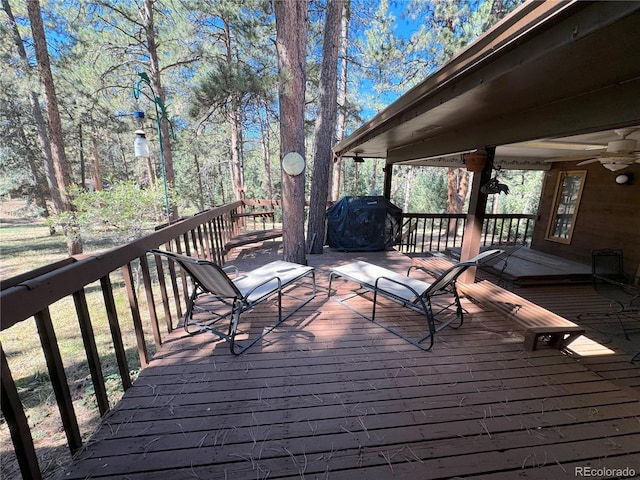 wooden deck with area for grilling and ceiling fan