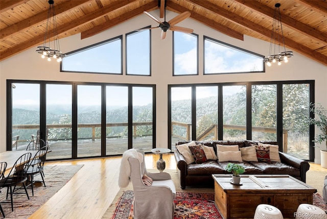 sunroom / solarium featuring a mountain view, plenty of natural light, lofted ceiling with beams, and wood ceiling