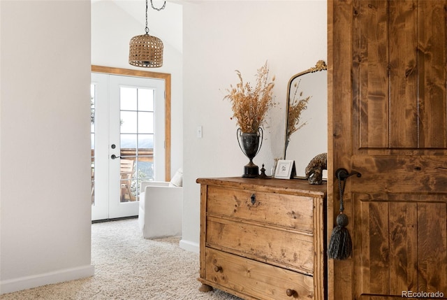 corridor featuring light carpet, vaulted ceiling, and french doors