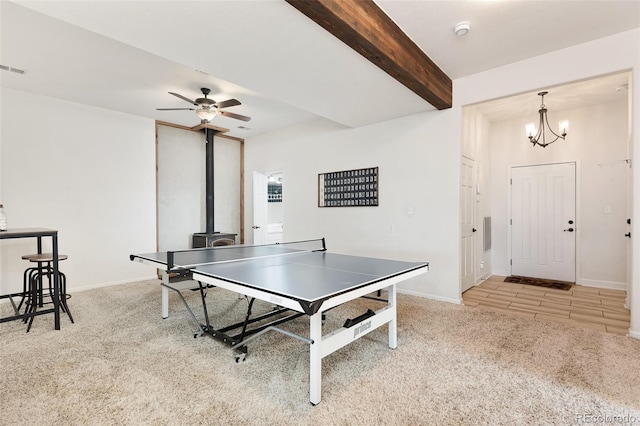 rec room with light colored carpet, ceiling fan with notable chandelier, and beamed ceiling