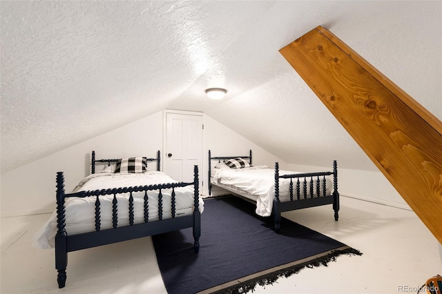 bedroom with lofted ceiling and a textured ceiling