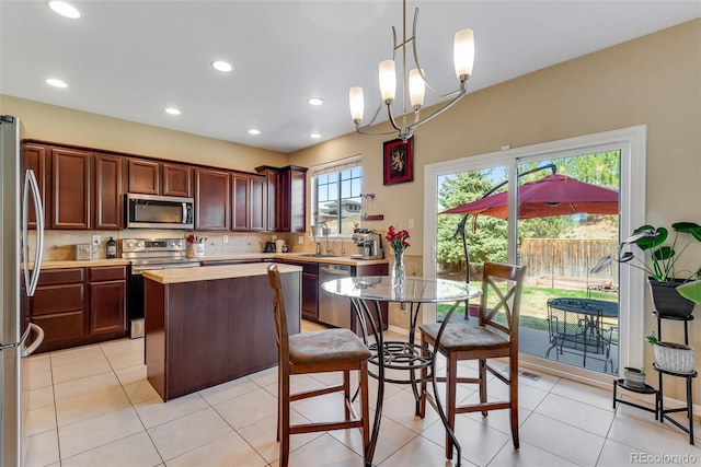 kitchen featuring recessed lighting, appliances with stainless steel finishes, decorative backsplash, and a center island