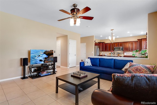 living area with recessed lighting, baseboards, light tile patterned floors, and ceiling fan with notable chandelier