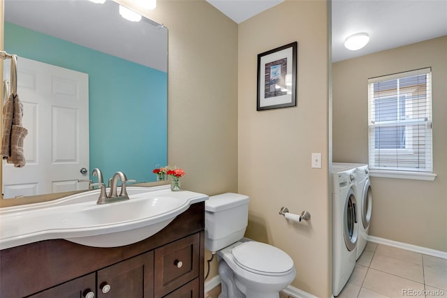 bathroom with vanity, toilet, tile patterned floors, baseboards, and washer and clothes dryer