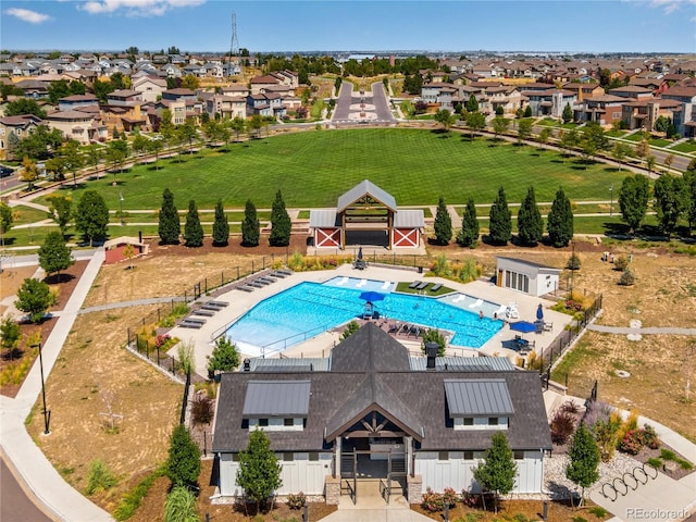 community pool featuring fence and a residential view