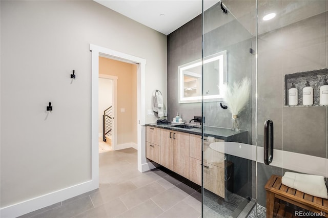 bathroom featuring baseboards, a shower stall, vanity, and tile patterned floors