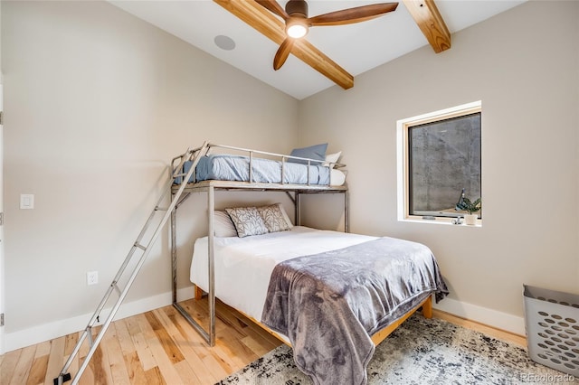 bedroom featuring ceiling fan, wood finished floors, beam ceiling, and baseboards