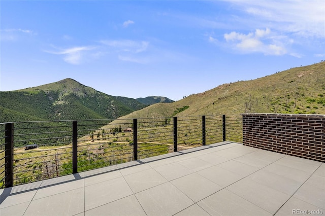 view of patio with a balcony and a mountain view