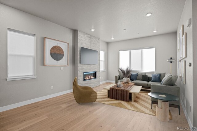 16605 Peak St, Broomfield, CO 80023 - living area with light wood-type flooring, a stone fireplace, and recessed lighting