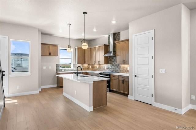 16605 Peak St, Broomfield, CO 80023 - kitchen with wall chimney range hood, stove, tasteful backsplash, light wood-style floors, and recessed lighting