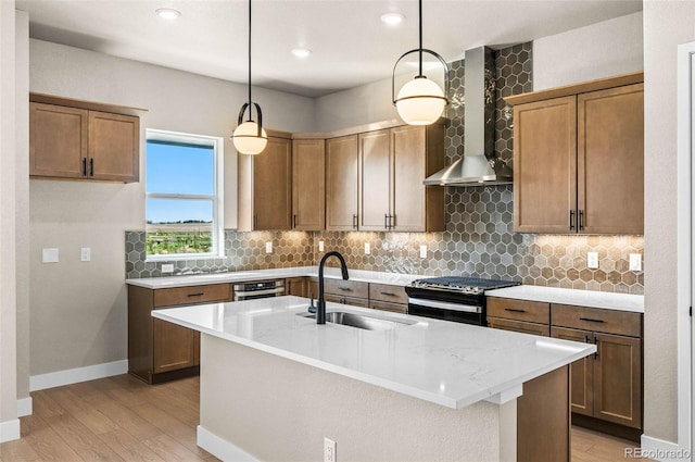 16605 Peak St, Broomfield, CO 80023 - kitchen with wall chimney exhaust hood, stove, light wood finished floors, decorative backsplash, and a kitchen island with sink