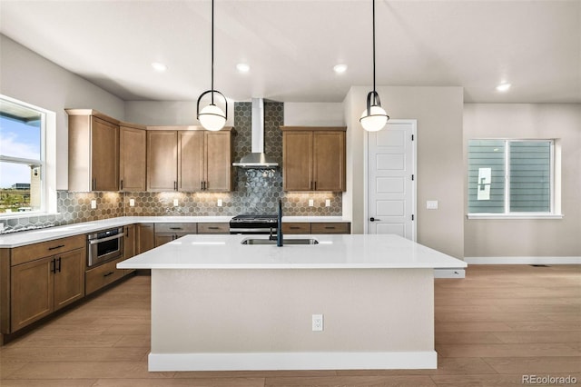 16605 Peak St, Broomfield, CO 80023 - kitchen featuring wall chimney range hood, backsplash, light wood finished floors, light countertops, and recessed lighting