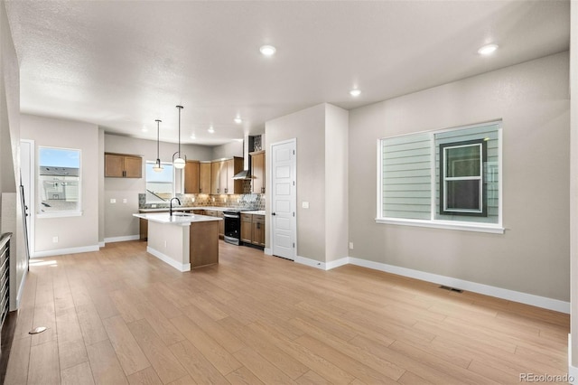 16605 Peak St, Broomfield, CO 80023 - kitchen featuring light countertops, electric stove, light wood-type flooring, open floor plan, and recessed lighting