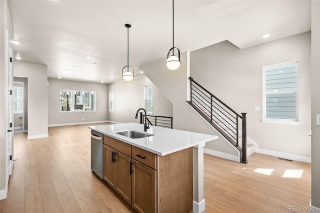 16605 Peak St, Broomfield, CO 80023 - kitchen with dishwasher, light wood-type flooring, open floor plan, brown cabinetry, and pendant lighting