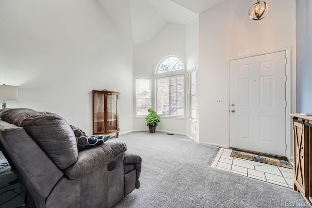 entrance foyer featuring light carpet and high vaulted ceiling