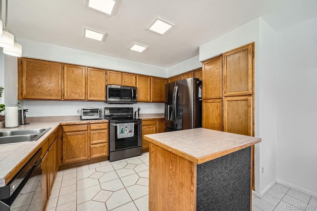 kitchen with sink, decorative light fixtures, tile counters, and black appliances