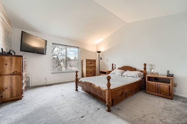 bedroom with light carpet and lofted ceiling