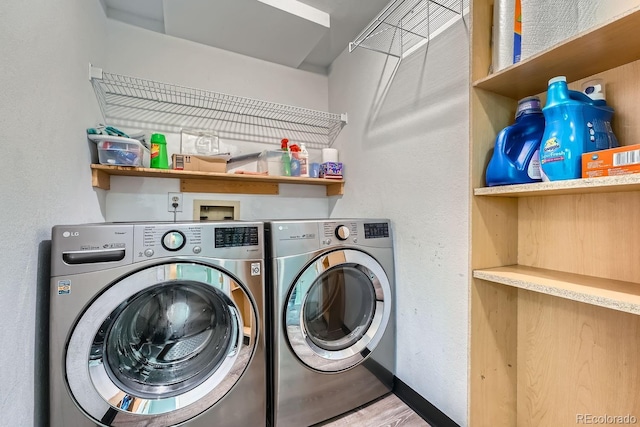 clothes washing area featuring hardwood / wood-style floors and washing machine and clothes dryer