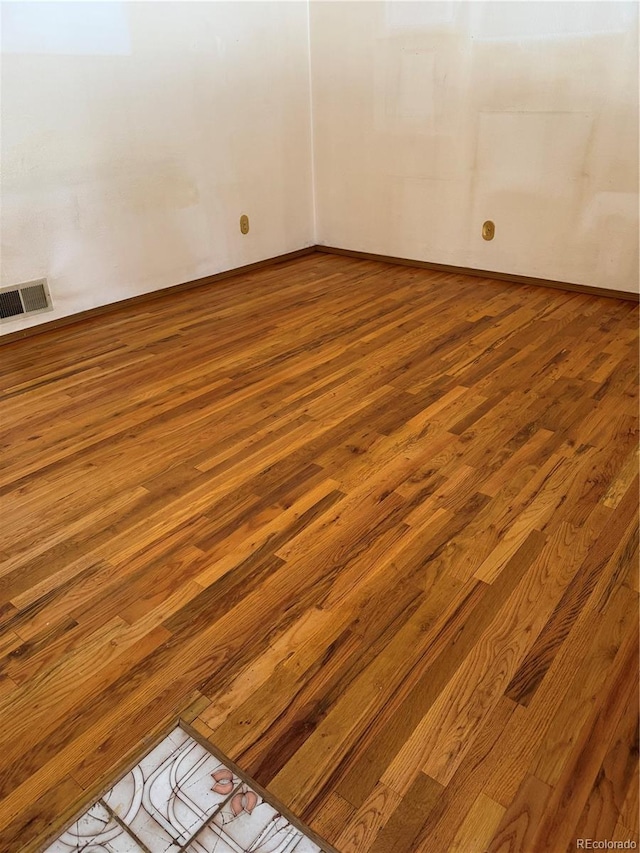 empty room with hardwood / wood-style flooring