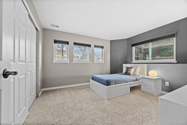 bedroom with light colored carpet and a closet