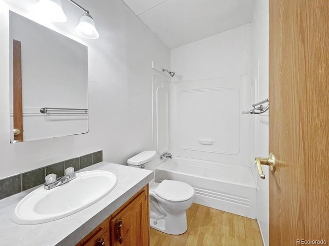 full bathroom with wood-type flooring, vanity, toilet, and shower / washtub combination